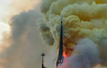 Des flammes et de une épaisse fumée s'échappent du toit de la cathédrale Notre-Dame de Paris le 15 avril 2019