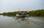 Des pĂȘcheurs en bateau le long d'une mangrove, le 18 octobre 2020 prĂšs des cĂŽtes de Karachi, au Pakistan