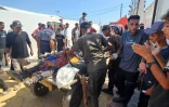 Des Palestiniens transportent des victimes abattues alors qu'elles attendaient des colis alimentaires à un point de distribution géré par la Fondation humanitaire de Gaza (GHF) à Rafah, dans le sud de la bande de Gaza, le 12 juillet 2025