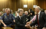 Oscar Pistorius serre la main de son oncle Arnold Pistorius avant d'être emmené en prison à l'issue de son procès le 21 octobre 2014 à Pretoria
