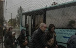 Des passagers à une station de bus où des filets antidrones ont été disposés le long de la route, le 30 octobre 2026 à Kherson, dans le sud de l'Ukraine 
