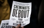 Une femme distribue des tracts lors d'une manifestation de cheminots à Paris, le 10 mai 2016