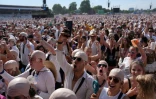 Des fans du rappeur américain Pitbull portent de faux crânes chauves avant un concert de l'artiste, le 10 juillet 2026 à Londres 