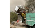 Des pompiers enveloppent d'une couverture ignifugée le panneau d'accueil du parc national de Sequoia, le 16 septembre 2021, en Californie