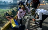 Des manifestants secourent des blessés après des heurts avec les forces de l'ordre vénézuéliennes, le 31 mai 2017 à Caracas