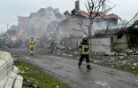 Des pompiers interviennent sur un incendie dans des maisons endommagées par une frappe russe dans la région de Kiev, le 25 mai 2025 en Ukraine