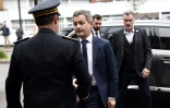 Le ministre de l'Intérieur Gérald Darmanin (c) arrive au commissariat de Roubaix pour rendre hommage aux trois policiers morts la veille dans un accident de la route, le 22 mai 2023 dans le Nord
