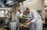 Des cuisiniers préparent des plats au restaurant "La Pyramide" à Vienne, le 20 mars 2025 en Isère