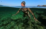 Lazaro Diaz, un retraité cubain de 75 ans, membre du club "Jeunesse accumulée", nage dans une piscine d'eau de mer à La Havane, le 17 mai 2025