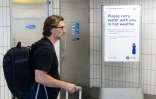 Un homme passe devant un panneau conseillant aux voyageurs d'emporter une bouteille d'eau avec eux, à la gare de Hammersmith, dans l'ouest de Londres, le 22 juin 2026