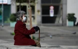 Une dame prend l'air, sur le banc d'une place de Milan, le 8 mars 2020