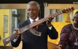 Kofi Annan, ancien secrétaire général de l'ONU, surnommé "rock star de la diplomatie" par certains, ici le 11 septembre 2007 à Vienne en Autriche, montre un fusil d'assaut AK-47 transformé en guitare   