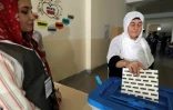 Une kurde irakienne dépose son bulletin de vote dans l'urne pour les élections législatives dans la région autonome du Kurdistan d'Irak, le 30 septembre 2018 