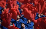 Des participants agitant des fleurs lors d'un défilé le 9 septembre 2018 à Pyongyang
