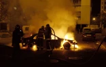 Des pompiers éteignent une voiture incendiée lors de violences déclenchées par la mort de deux adolescents, le 30 octobre 2005 à Clichy-sous-Bois, en Seine-Saint-Denis