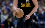Nikola Jokic porte le ballon lors d'un match de saison régulière de NBA des Nuggets face aux Phoenix Suns, le 27 mars 2024 à Denver