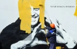 Un homme efface une fresque murale représentant l'opposant russe Alexeï Navalny, à Saint-Petersbourg le 28 avril 2021