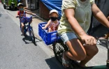 Une famille à vélo dans une rue de Bangkok, le 7 mai 2020