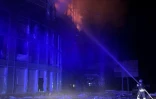 Un pompier travaille à l'extinction d'un incendie dans un immeuble touché par une frappe russe à Zaporijjia, en Ukraine, le 2 janvier 2026