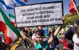 Une manifestante brandit une pancarte assurant que l'équipe de football d'Iran "ne représente pas le peuple", près du SoFi Stadium à Inglewood, près de Los Angeles, le 15 juin 2026
