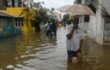 Des habitants de Pondichéry pataugent dans une rue inondée après de fortes pluies liées au cyclone Nivar, le 26 novembre 2020