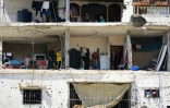 Des familles palestiniennes retournent dans leurs maisons gravement endommagées dans un immeuble touché lors d'un précédent bombardement israélien, dans la ville de Khan Younés, dans le sud de la bande de Gaza, le 30 juin 2024