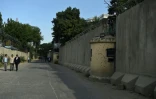 Des Afghans marchent dans une rue de la Zone verte protégée par des murs de béton de 6 mètres de haut et des barbelés à leur sommet, le 19 juin 2019 à Kaboul