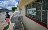 Une femme passe devant une maison en vente à La Havane, le 1er octobre 2024 