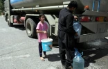 Des Kurdes irakiens s'approvisionnent en eau lors d'une distribution par camion, à Erbil, capitale du Kurdistan autonome dans le nord de l'Irak, qui souffre d'une pénurie d'eau courante, le 25 juillet 2024