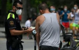 Un policier municipal effectue un contrĂ´le du port du masque Ă Barcelone (Espagne) le 9 juillet 2020