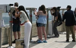 Des touristes utilisent des jumelles pour observer le territoire nord-coréen depuis une plate-forme d'observation sud-coréenne située à l'Écoparc de la Paix d'Aegibong, à Gimpo, le 1er juillet 2026 