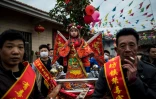 Des enfants, maquillés et habillés de costumes bordés et colorés, en parade, debout sur des palanquins, dans les rues de Tufang, le 11 février 2017 dans l'est de la Chine