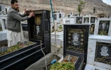 Talib Hussain nettoie la pierre tombale sur laquelle est gravé le portrait de son père décédé, dans un cimetière de Quetta, au Pakistan, le 17 février 2026