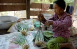 Im Chaem ancienne cadre du régime Khmer rouge vend des oignons verts devant chez elle à Anlong Veng, le 25 février 2018