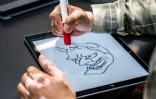 Le tatoueur japonais Ichi Hatano dessine une "hannya" (fantôme femme)  sur tablette tactile dans son studio à Tokyo, le 22 juin 2021
