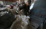 Un ouvrier palestinien prépare le plastique avant de la faire fondre pour en extraire du pétrole dans un atelier dans la bande de Gaza, le 23 août 2022