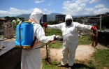 Des membres de le Protection civile se désinfectent après un enterrement à San Cristobal au Venezuela le 1er septembre 2020