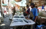 Des pêcheurs vendent leur poisson dans un marché de la ville portuaire de Hodeida, aux mains des rebelles Houthis, dans l'ouest du Yémen, le 14 décembre 2018