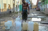 Un homme collecte de l'eau potable à un point de ravitaillement public dans une rue de La Havane, le 6 octobre 2026