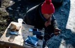 Un migrant recharge son téléphone portable à Sid en Serbie, près de la frontière avec la Croatie, le 7 décembre 2017