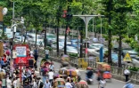 Des automobilistes passent près d'un système de contrôle du trafic basé sur l'intelligence artificielle dans la capitale bangladaise Dacca, le 14 mai 2026  