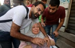 Un homme réconforte une Palestinienne blessée dans une frappe aérienne israélienne, le 5 août 2022 à Gaza