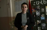 La proviseure Anouch Hakobian devant d'un tableau couvert de photos d'hommes tombés au combat, dans son école à Parakar, près d'Erevan, le 6 octobre 2023 en Arménie