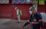Des employés désinfectent un marché alimentaire pour lutter contre l'épidémie de coronavirus, le 24 mars 2020 à Mexico