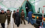 Photo non datée transmise le 28 janvier 2022 par l'agence nord-coréenne Kcna du leader nord-coréen Kim Jong Un (c) visitant une usine d'armement dans un endroit non précisé