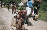 Une fillette porte une charge durant sa fuite du bourg de Bambo, dans le nord Kivu, en RDC, après une attaque des rebelles du M23, le 26 octobre 2023