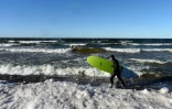 La surfeur Nikita Kononovich, 29 ans, entre dans les eaux glacées du golfe de Finlande près du village de Lipovo près de Saint-Petersbourg le 17 février 2019