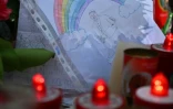 Un dessin représentant le pape François sous un arc-en-ciel déposé au pied de la statue de Jean-Paul II devant l'hôpital Gemelli à Rome où le pape François est soigné pour une pneumonie, le 14 mars 2025