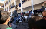 Tareq al-Ennabi, un Palestinien de 25 ans, donne un cours d'anglais à des enfants déplacés dans une école devenue camp de déplacés à Rafah, dans le sud de la bande de Gaza, le 29 novembre 2023