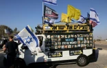 Une camionnette sur laquelle sont accrochés des photos d'otages israéliens ainsi que des drapeaux garée lors d'une manifestation  près du kibboutz Beeri, dans le sud d'Israël, appelant à la libération des otages retenus à Gaza, le 20 août 2025
